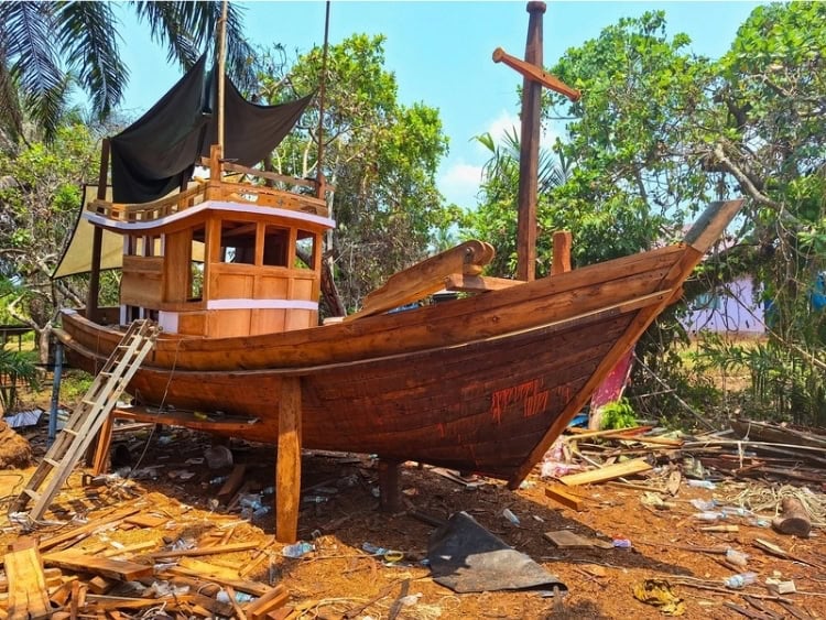 A Thai-style squid boat under construction in a roadside coconut grove, away from the ocean. Photo by Michael Cullen
