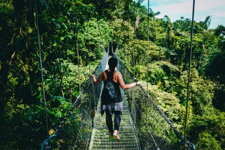 A woman traveler crossing a bridge in Costa Rica. Photo by Fabio Fistarol, Unsplash