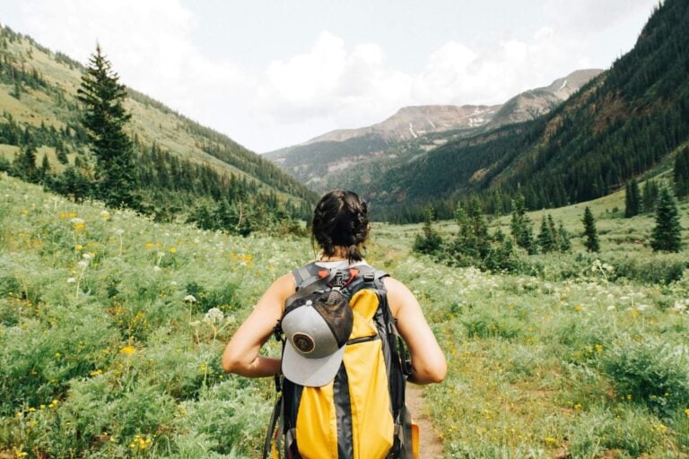 Person with backpack in a valley, Crested Butte, United States. Photo by Holly Mandarich, Unsplash