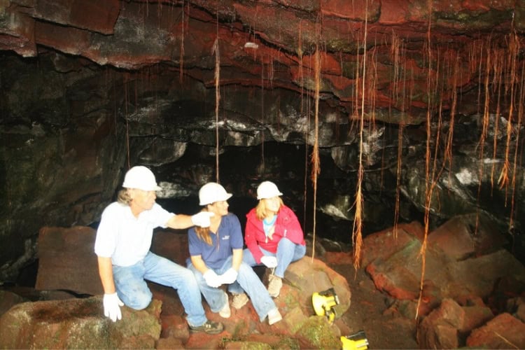 Kilauea Caverns with formations of varied colors hanging overhead and rising from the floor. Photo by Brent Cassie