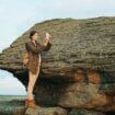 Young tourist woman backpacker on a large rock formation capturing the sunset landscape. Photo by Vitaly Gariev, Unsplash