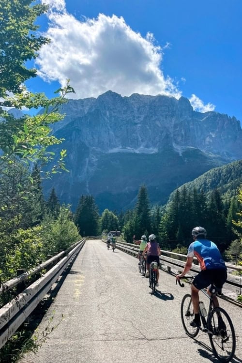 Bikers on a bridge headed to Alpine peaks. Photo by Craig Stoltz