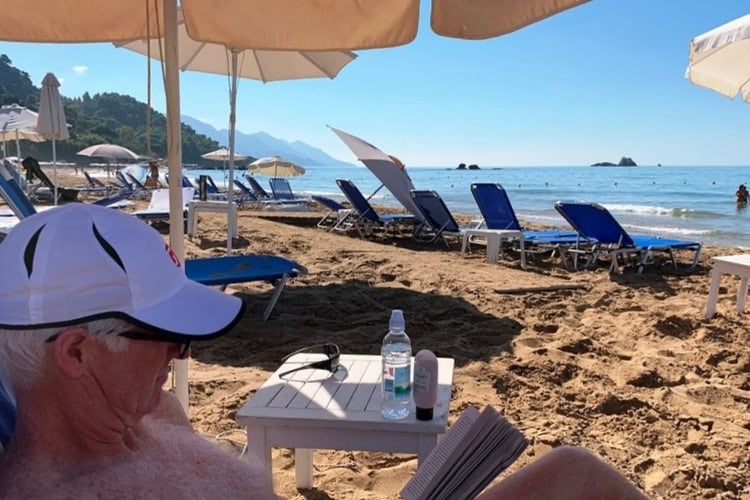 Brent relaxing beneath a thatched umbrella on the beach. Photo by Jane Cassie