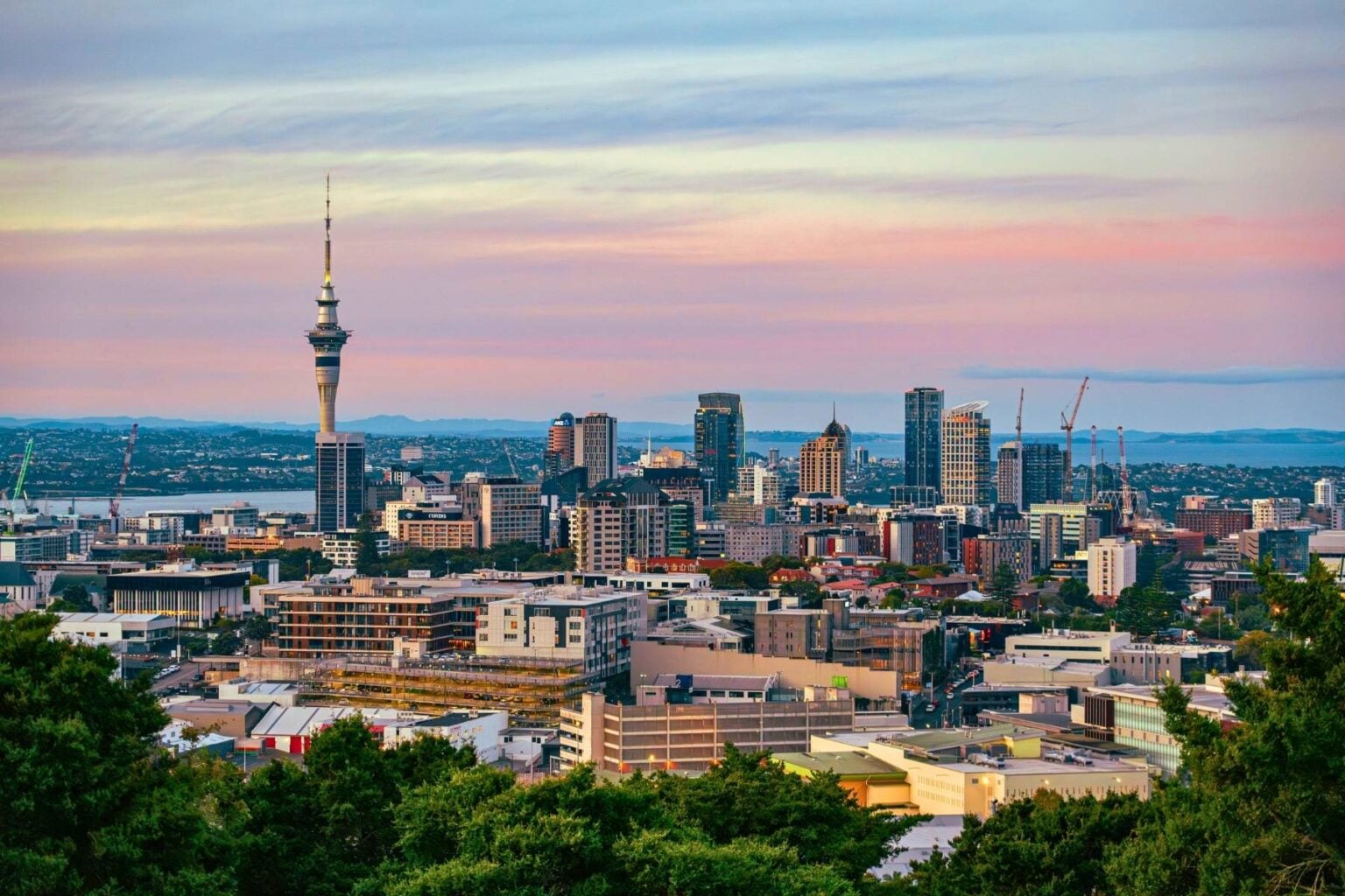 Captivating view of Auckland's skyline at dusk featuring the iconic Sky Tower under a colorful sky. Photo by Donovan Kelly, Pexels