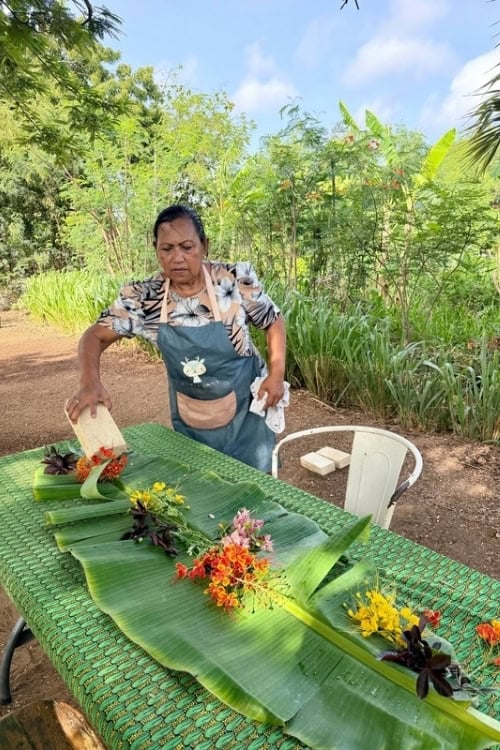 Chef Rositta Bakri of Nature Cooking School Bonaire strewing flowers on table. Photo by Susan Greenberg