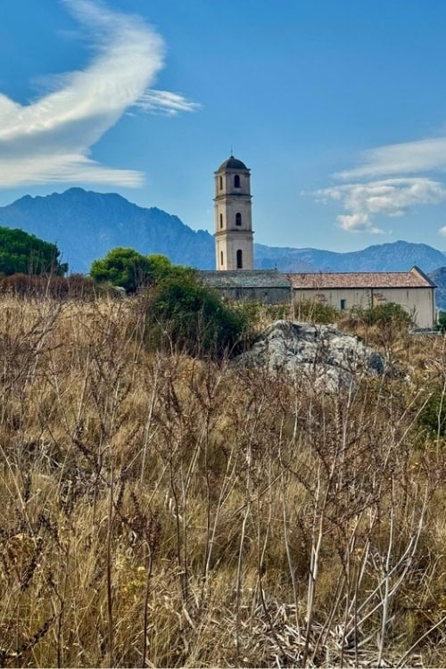 The Church of the Anunciation stands out boldly against the surrounding mountains in Sant'Antonino. Photo by Diana Ballon
