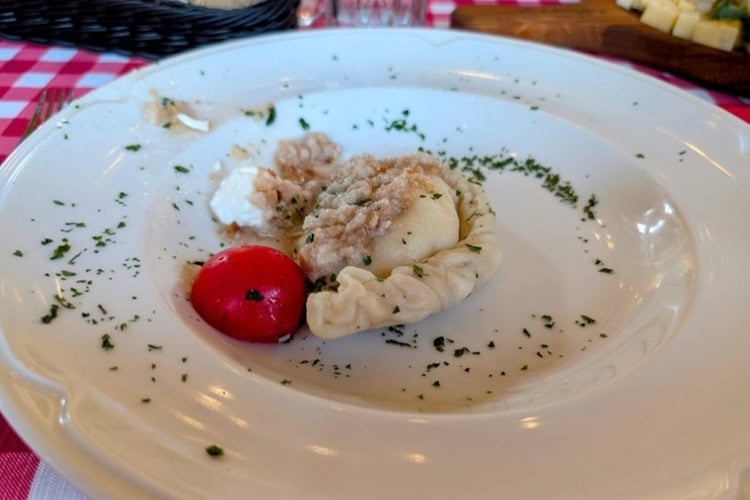 Krapi, a kind of Slovenian dumpling often filled with cheese, is draped with minced lard and often served with sour milk. Photo by Craig Stoltz