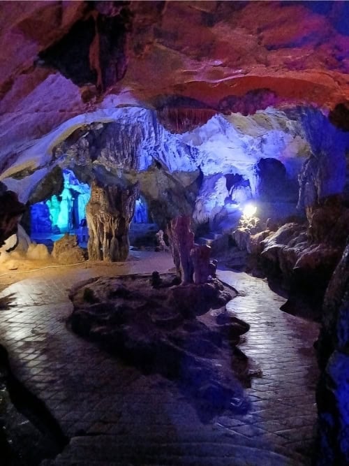 Dramatic rock formations illuminated inside a cave in Vang Vieng, Laos. Photo by Shivika Singh
