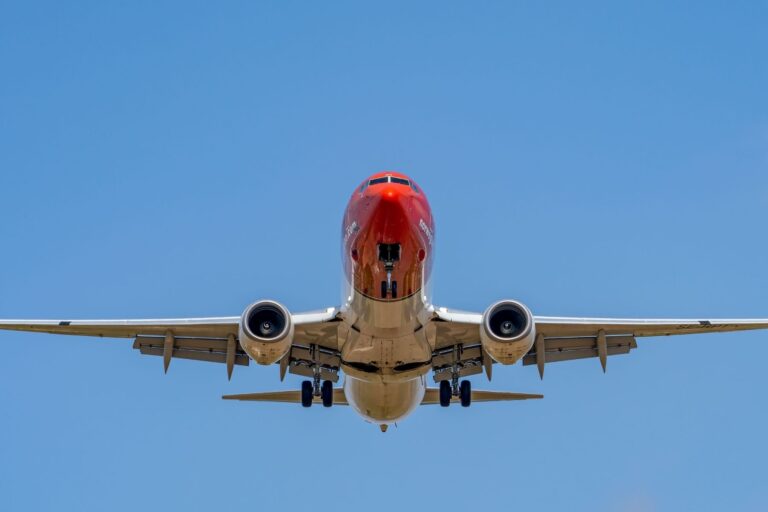 Red commercial airplane landing at Manises Airport, Spain. Photo by Rafael Minguet Delgado, Pexels