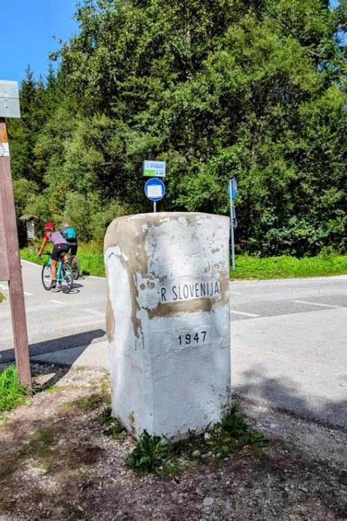 Slovenia Italy border stone, once the subject of heated Treaty of Paris negotiations, now mainly used for selfies or a water break. Photo by Craig Stoltz