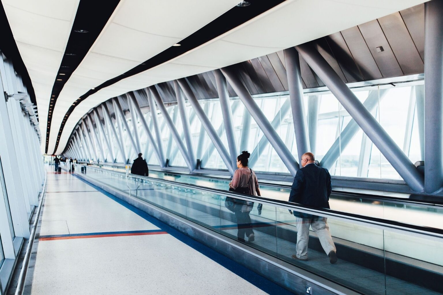 Travelers walking through an airport corridor. Photo by Negative Space, Pexels