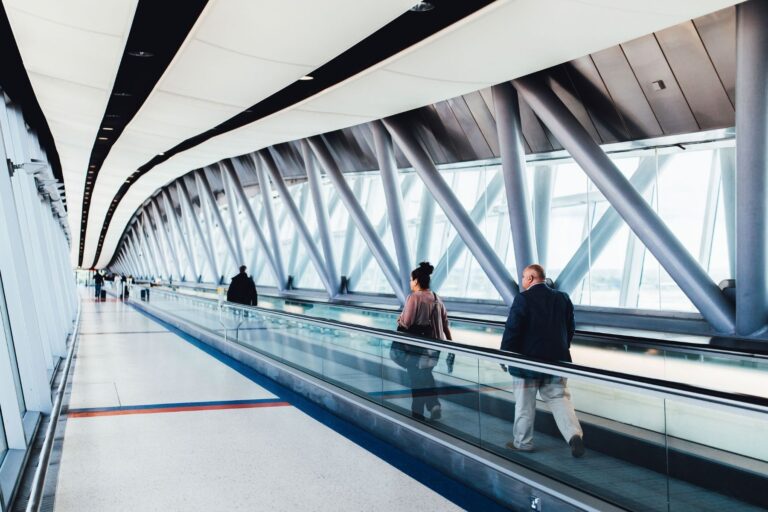 Travelers walking through an airport corridor. Photo by Negative Space, Pexels