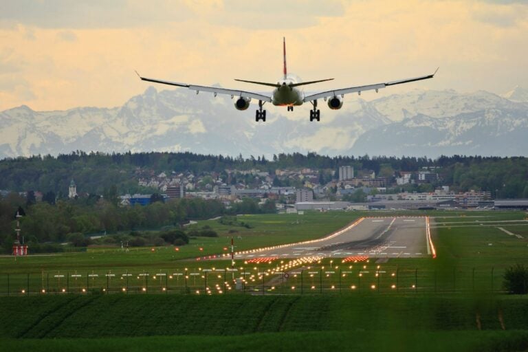 Commercial airplane landing on runway. Photo by Pascal Meier, Unsplash