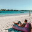 Man sitting on a bean bag on the beach. Photo by Johnny Africa, Unsplash