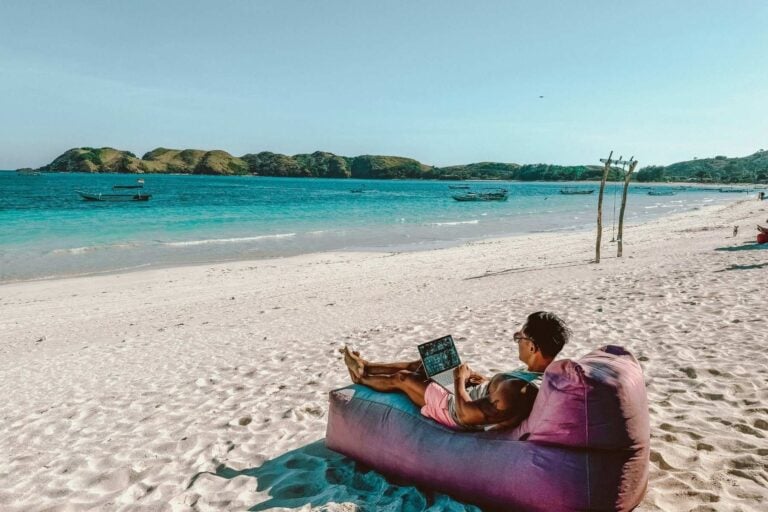 Man sitting on a bean bag on the beach. Photo by Johnny Africa, Unsplash