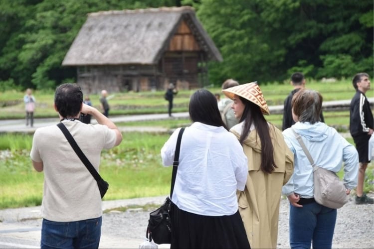 Visitors admiring a traditional thatched-roof house in Shirakawa-go Village. Photo by Masayoshi Sakamoto