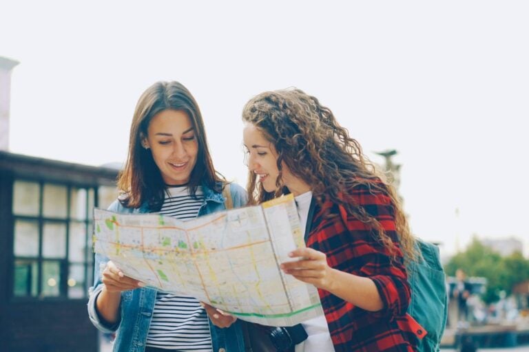 Two women exploring the town with backpacks. Photo by Vitaly Gariev, Unsplash