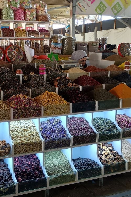 Stands offering beautiful displays of spices, dried fruits, and dried flowers for sachets brighten the aisles at Chorsu Market